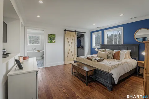 a bedroom with bed and wooden floor