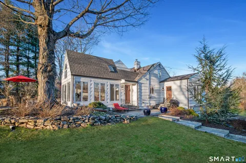 a front view of a house with a yard and fountain