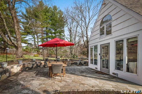 a view of a patio with a table and chairs under an umbrella