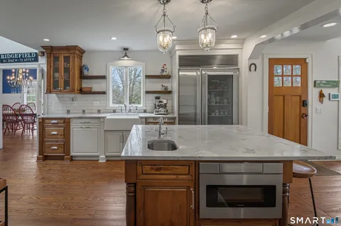 a kitchen with kitchen island granite countertop a stove and a sink