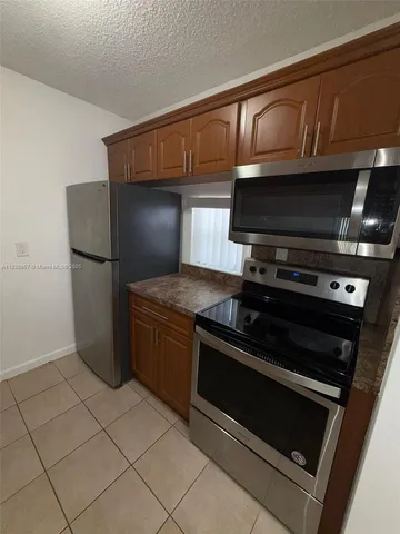 a kitchen with granite countertop a stove and a microwave