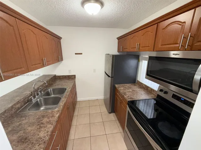 a kitchen with granite countertop a stove and a microwave with wooden floor