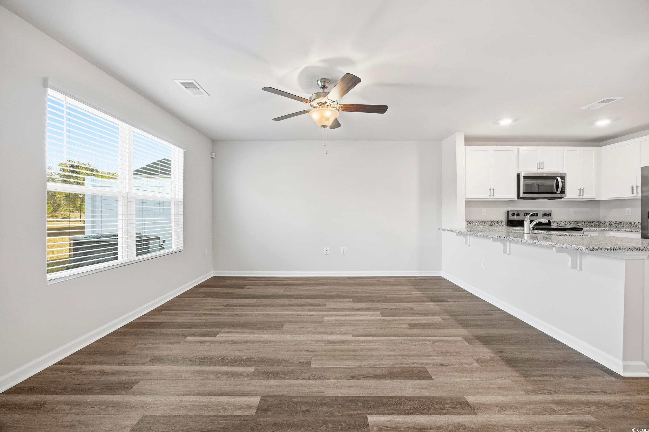 322 Honeystone Street Conway, SC 29526 - Photo 10 of 30 Unfurnished living room featuring dark wood-type flooring and a ceiling fan