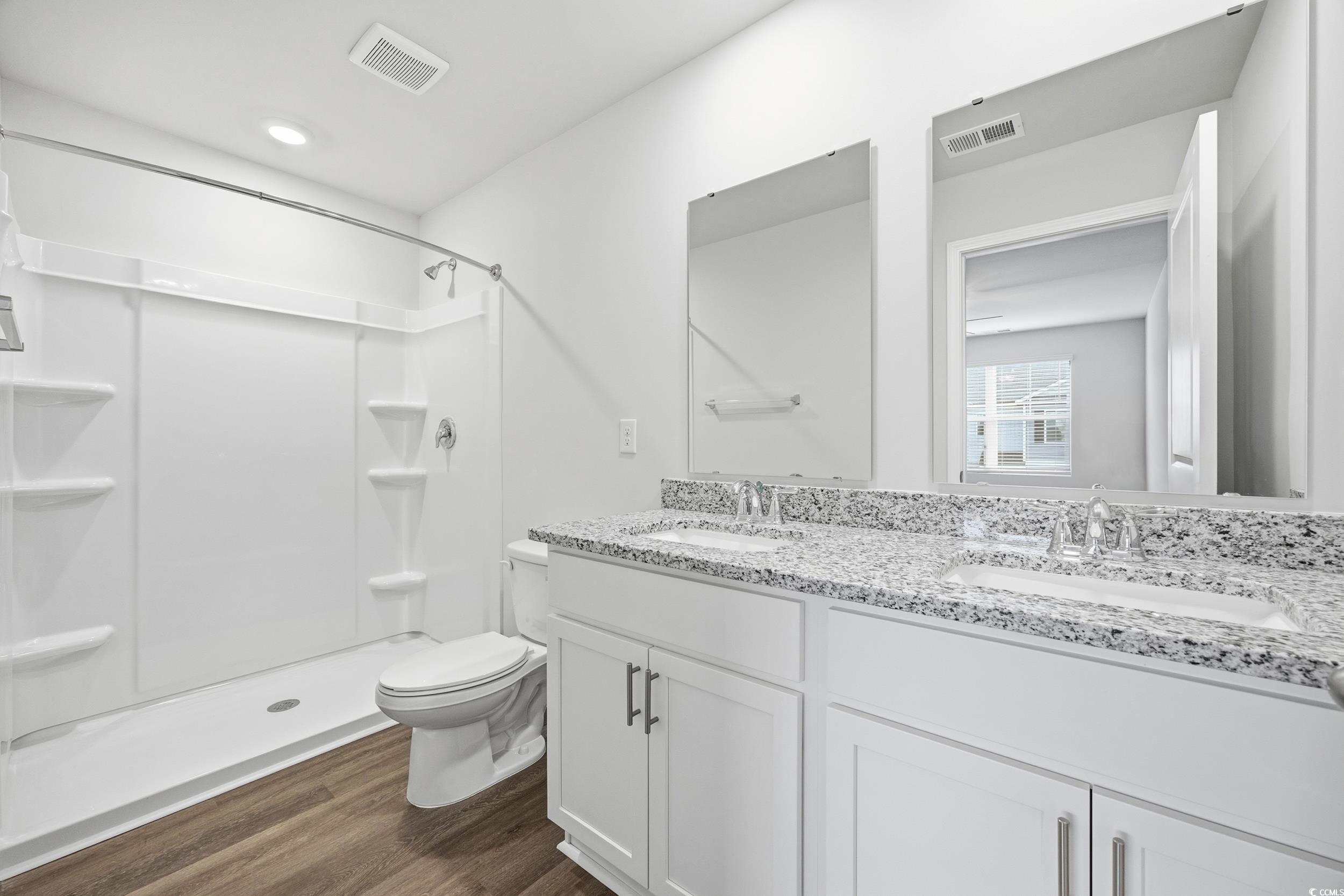 322 Honeystone Street Conway, SC 29526 - Photo 17 of 30 Bathroom with a stall shower, double vanity, and dark wood-type flooring