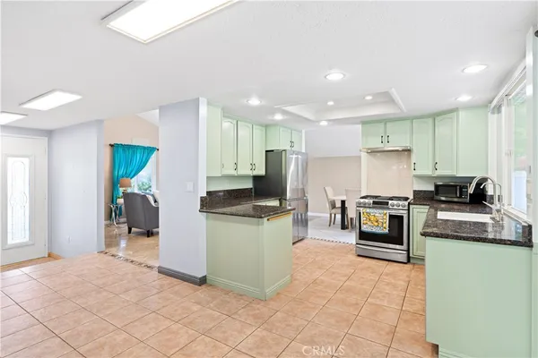 a kitchen with stainless steel appliances granite countertop a stove top oven a sink a counter top space and cabinets