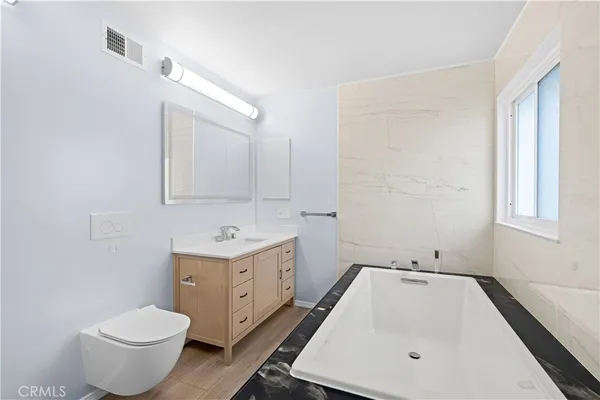 a bathroom with a sink toilet and window