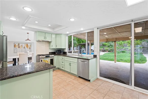 a kitchen with granite countertop a sink and white cabinets