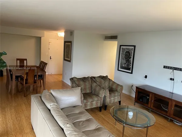 a view of a livingroom with wooden floor and workspace