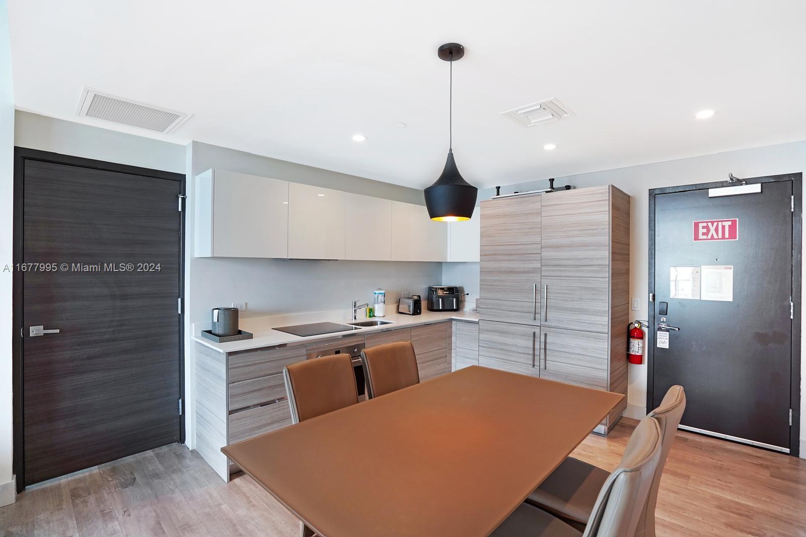 South Central Beach Hollywood, FL 33019 - Photo 13 of 23 a kitchen with stainless steel appliances kitchen island granite countertop a refrigerator a sink and wooden floors