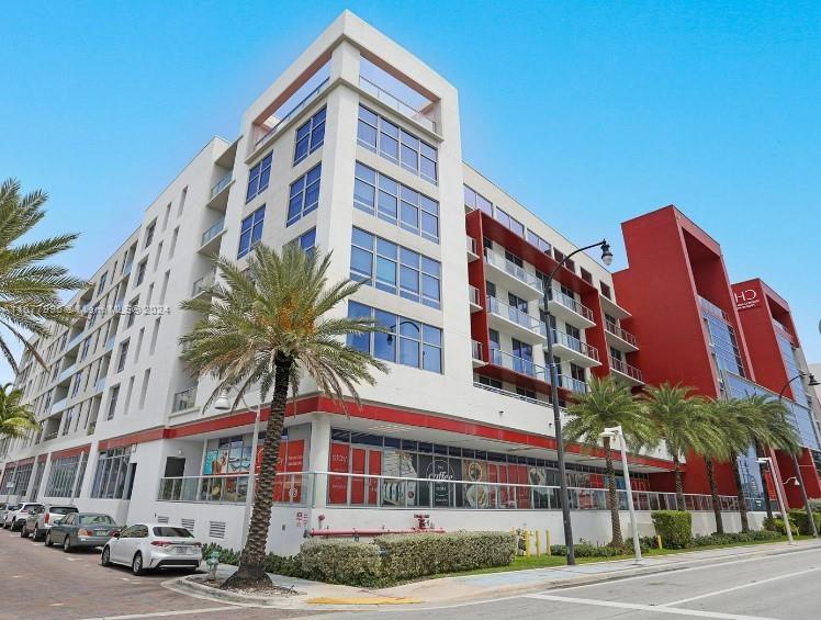 South Central Beach Hollywood, FL 33019 - Photo 19 of 23 a front view of a building with lot of cars and trees