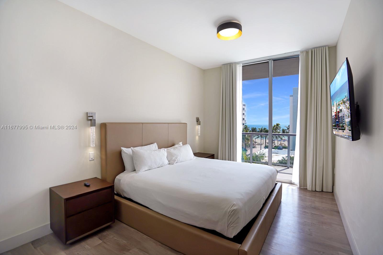 South Central Beach Hollywood, FL 33019 - Photo 5 of 23 a bedroom with a bed and a flat tv screen on a dresser