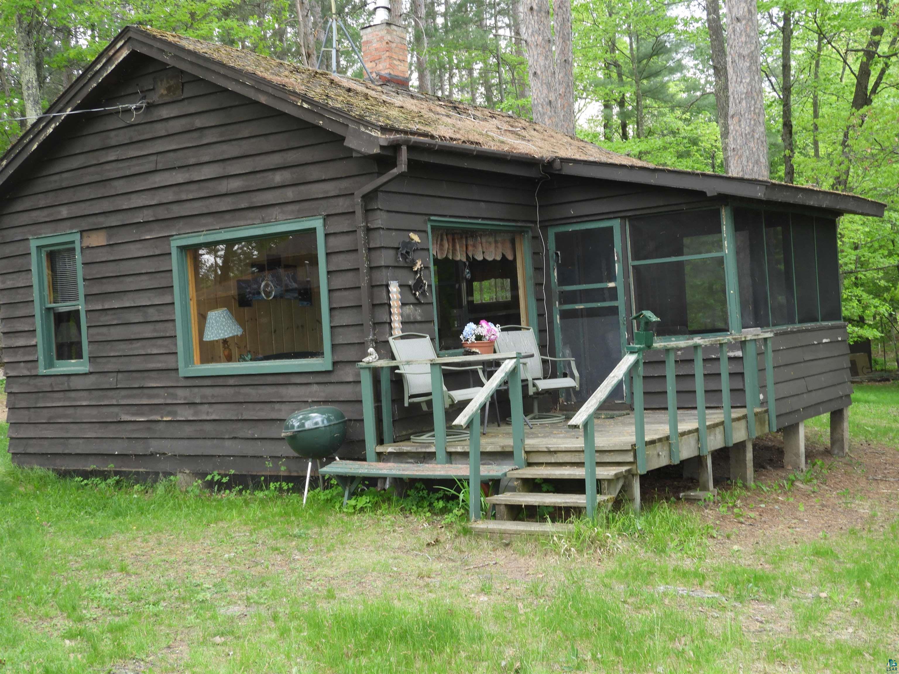 66490 Mieritz Road Iron River, WI 54847 - Photo 13 of 23 View of front of house featuring a chimney, a wooden deck, and a sunroom
