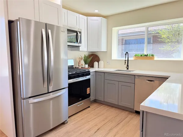 a kitchen with a refrigerator sink and cabinets