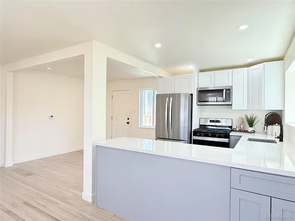 a kitchen with granite countertop a refrigerator sink and stove