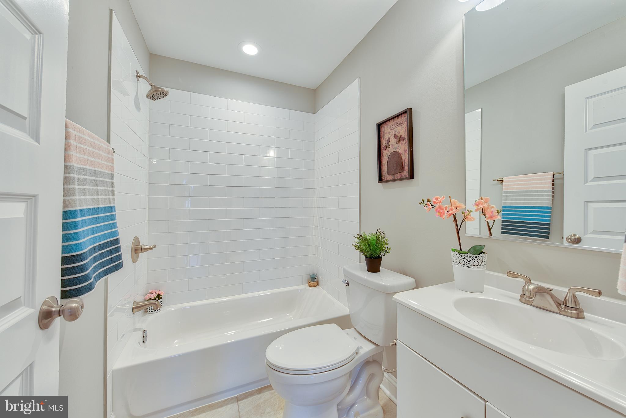 115 North Decker Avenue Baltimore, MD 21224 - Photo 21 of 30 a bathroom with a sink a toilet a mirror a vanity and shower