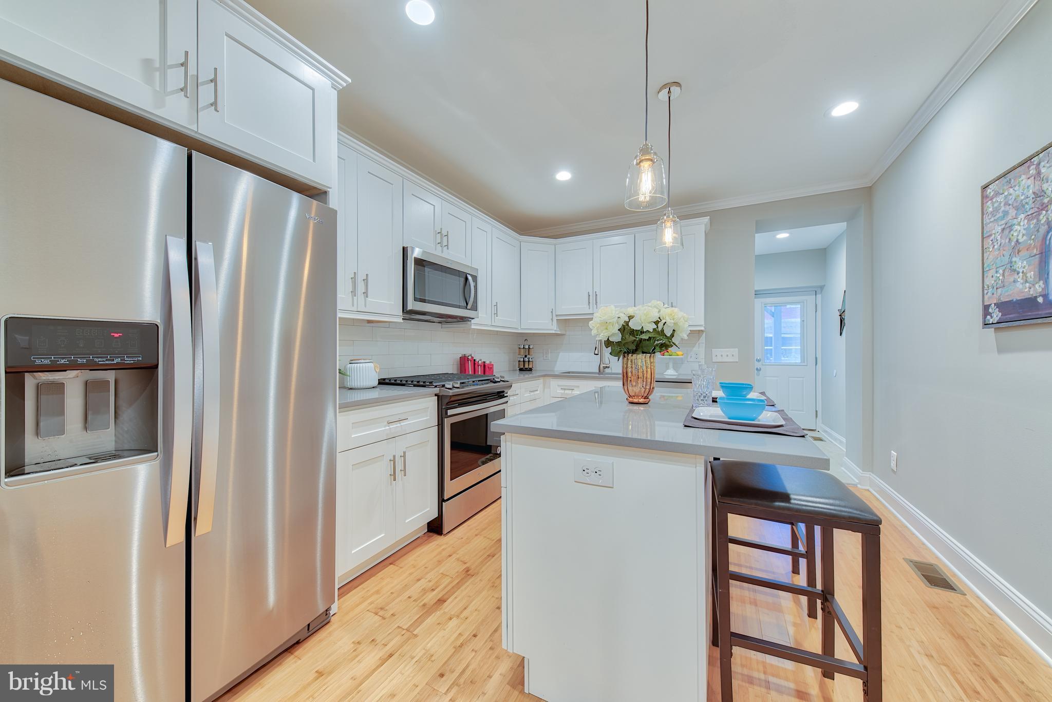 115 North Decker Avenue Baltimore, MD 21224 - Photo 8 of 30 a kitchen with kitchen island granite countertop a sink appliances cabinets and furniture