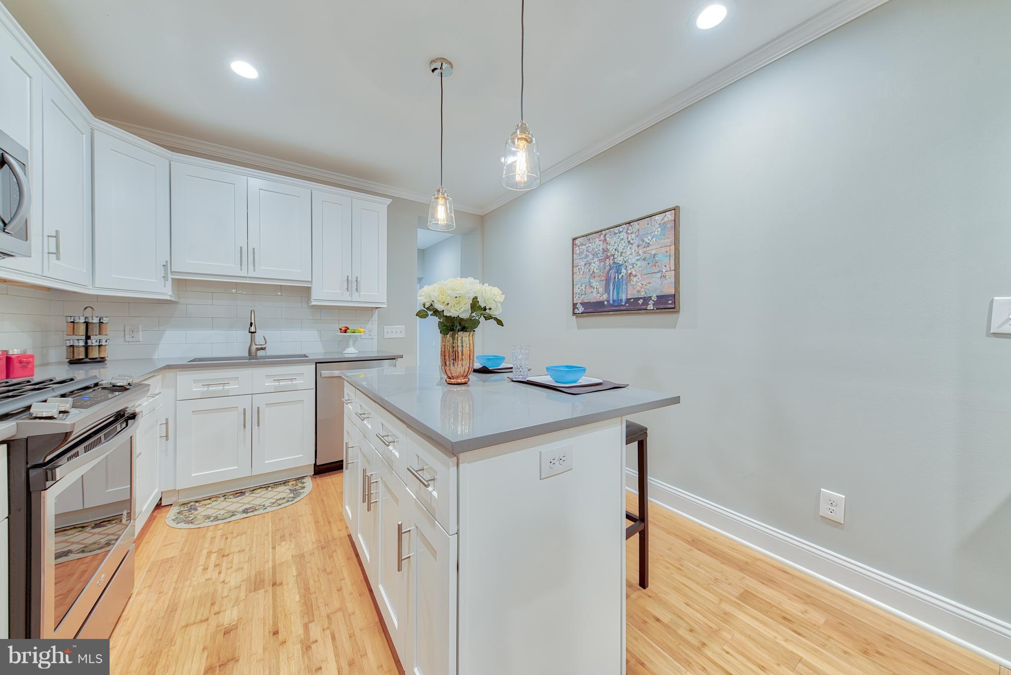 115 North Decker Avenue Baltimore, MD 21224 - Photo 9 of 30 a kitchen with a sink a stove a refrigerator and cabinets