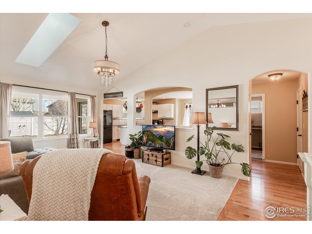5771 Mountain Shadows Boulevard Firestone, CO 80504 - Photo 11 of 40 a living room with furniture a chandelier and a dining table