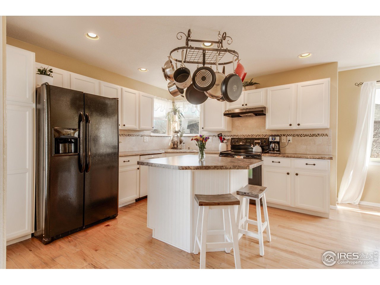 5771 Mountain Shadows Boulevard Firestone, CO 80504 - Photo 13 of 40 a kitchen with stainless steel appliances granite countertop a chimney a sink and refrigerator