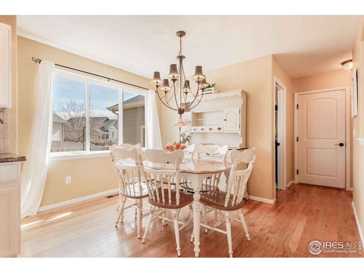 5771 Mountain Shadows Boulevard Firestone, CO 80504 - Photo 14 of 40 a view of a dining room with furniture a chandelier and wooden floor