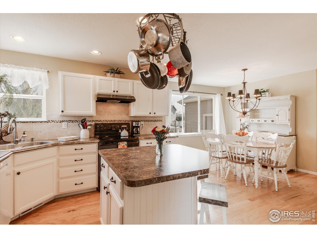 5771 Mountain Shadows Boulevard Firestone, CO 80504 - Photo 15 of 40 a kitchen with kitchen island granite countertop a table and chairs in it