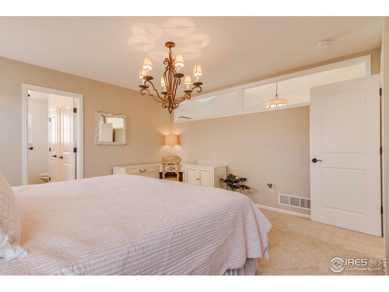 5771 Mountain Shadows Boulevard Firestone, CO 80504 - Photo 19 of 40 a bedroom with a large bed and chandelier