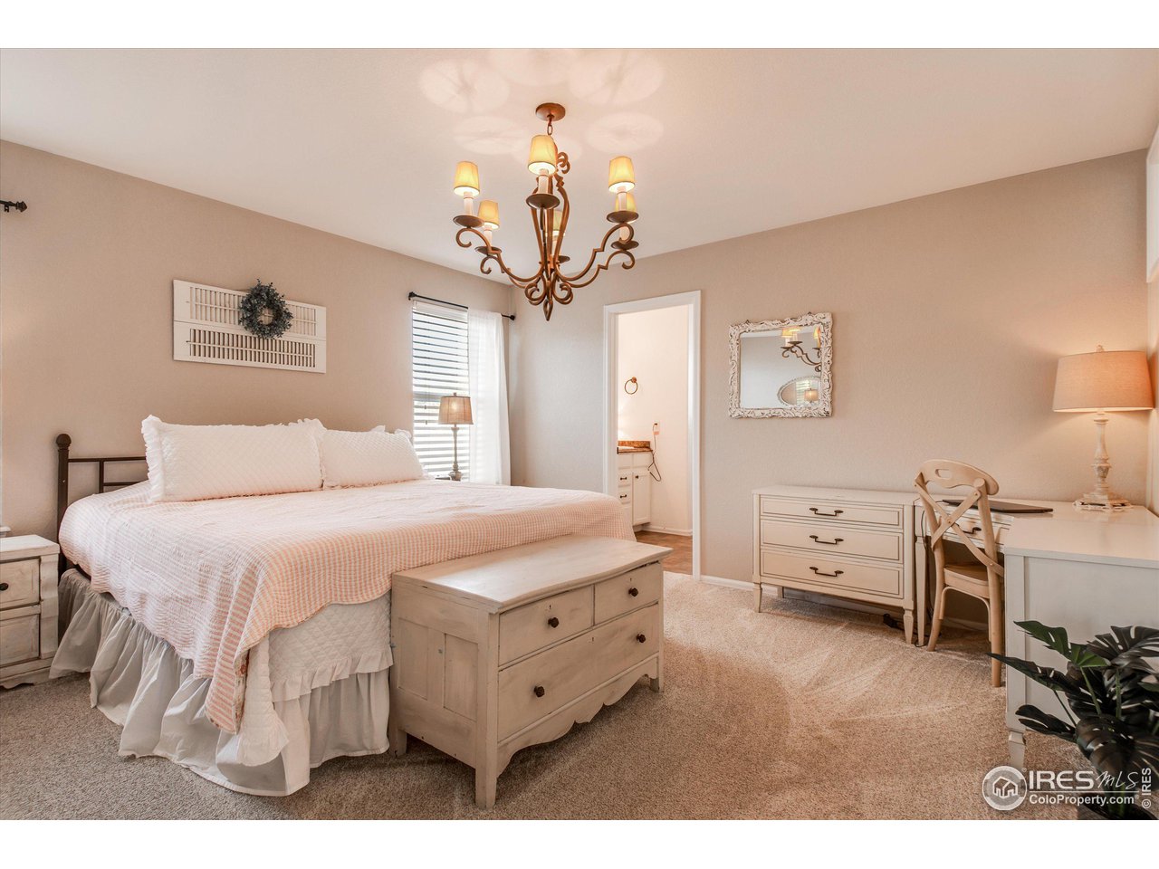 5771 Mountain Shadows Boulevard Firestone, CO 80504 - Photo 20 of 40 a bedroom with a bed and a chandelier