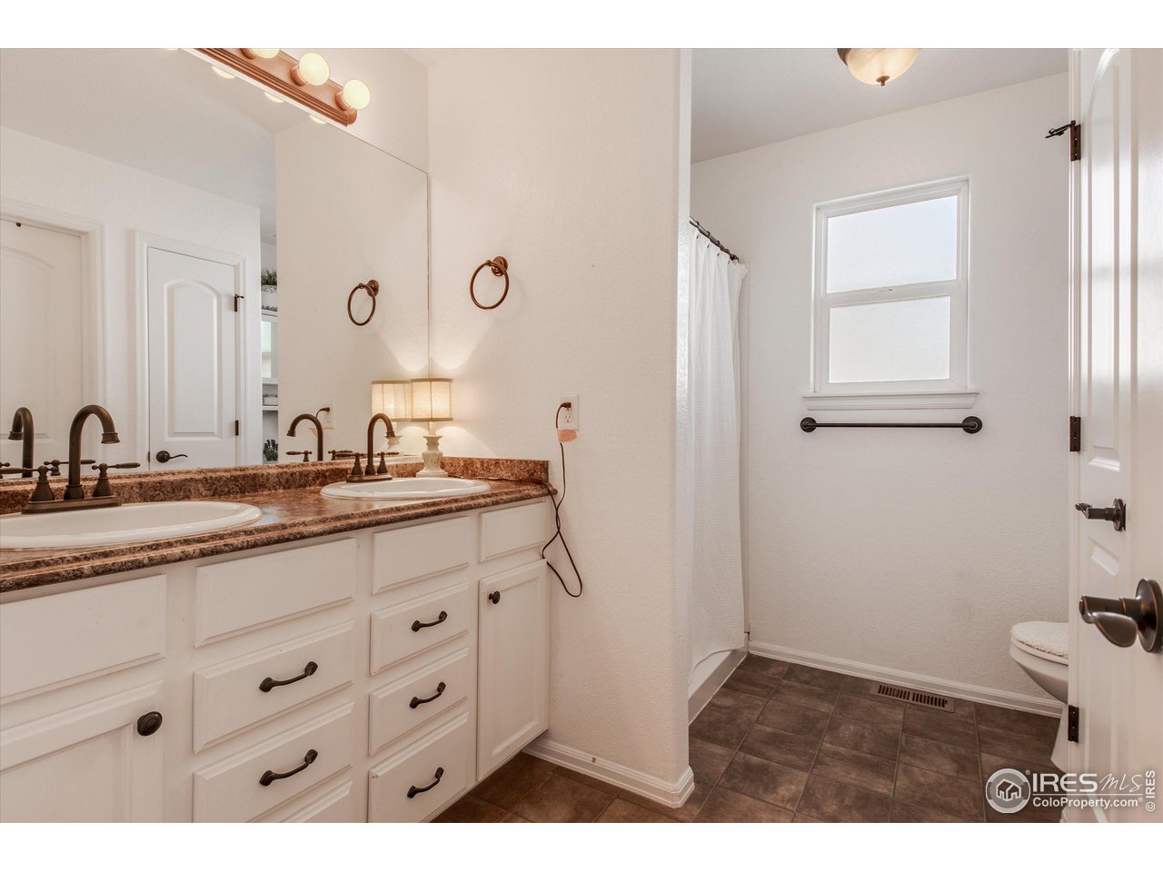 5771 Mountain Shadows Boulevard Firestone, CO 80504 - Photo 21 of 40 a bathroom with double sink and a mirror