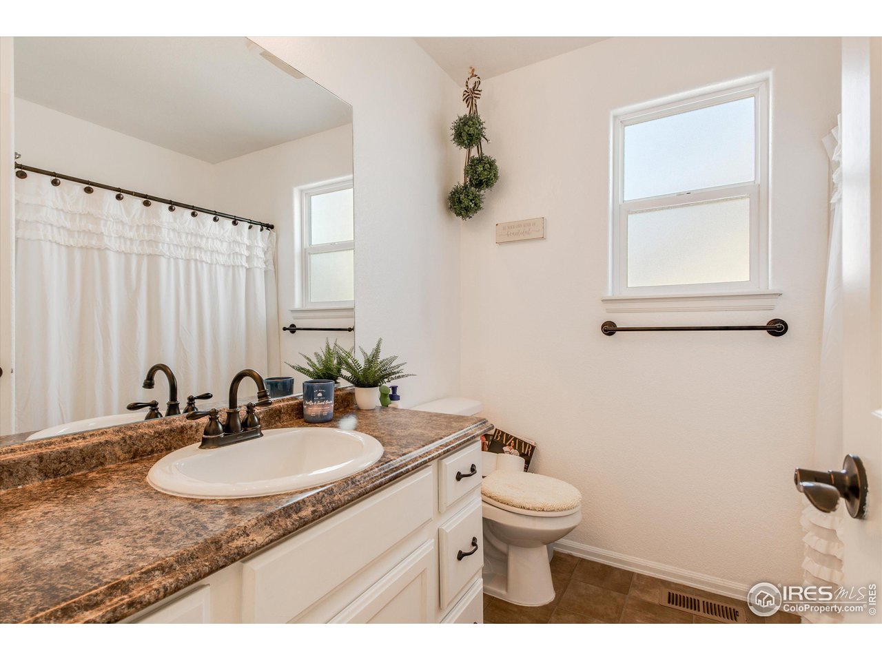 5771 Mountain Shadows Boulevard Firestone, CO 80504 - Photo 24 of 40 a bathroom with a granite countertop sink toilet and a mirror