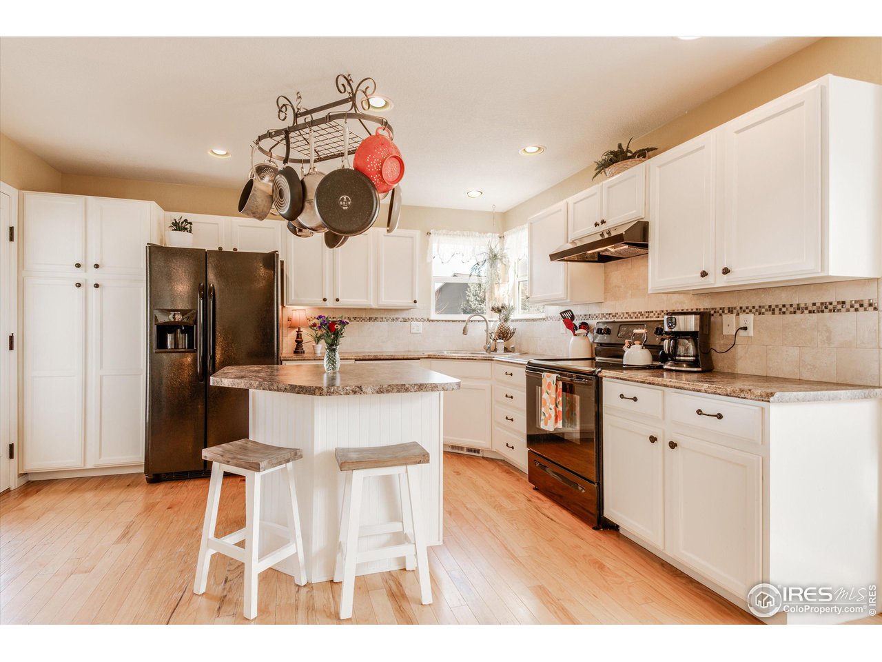5771 Mountain Shadows Boulevard Firestone, CO 80504 - Photo 9 of 40 a kitchen with white cabinets and stainless steel appliances