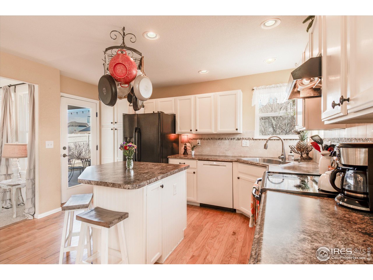 5771 Mountain Shadows Boulevard Firestone, CO 80504 - Photo 10 of 40 a kitchen with a sink dishwasher and a stove with wooden floor