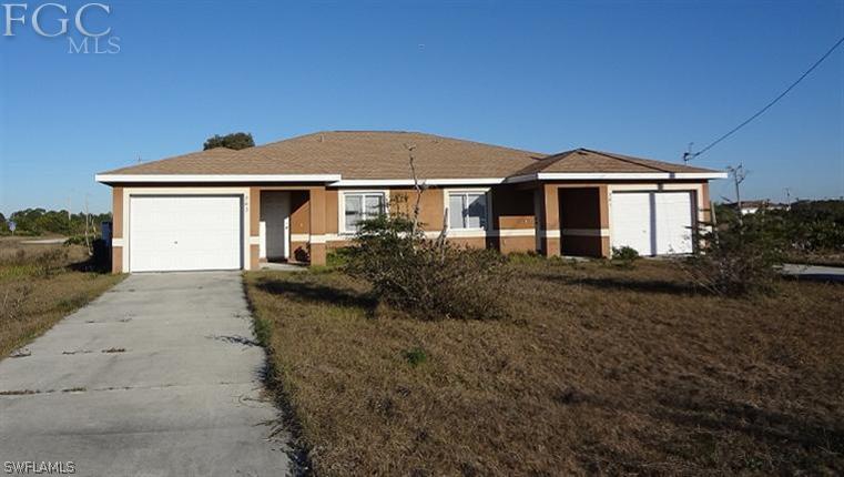 741 Alabama Road South Lehigh Acres, FL 33974 - Photo 1 of 8 a front view of a house with a yard