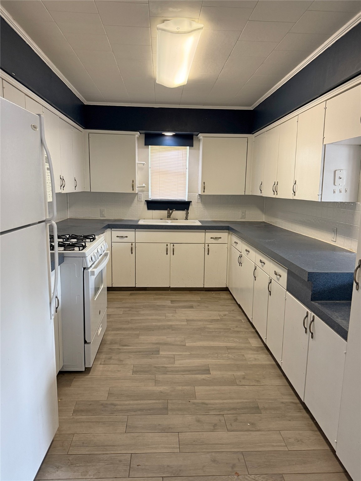 508 Rals Drive Onalaska, TX 77360 - Photo 16 of 42 a kitchen with wooden cabinets sink and white appliances