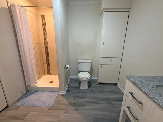 a white toilet sitting next to a shower curtain