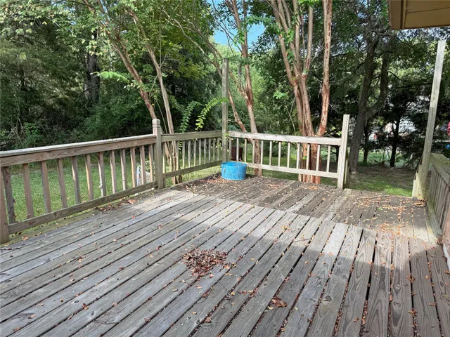 a view of a wooden deck with a yard and wooden fence