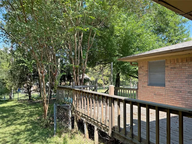 a view of a wooden deck and a forest