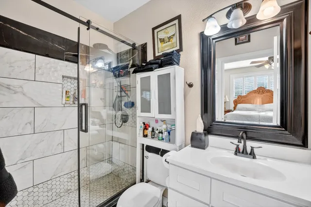 a bathroom with a sink a toilet and shower