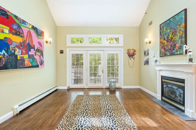a view of a livingroom with wooden floor and a fireplace