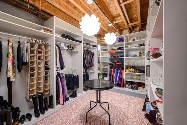 a view of walk in closet with clothes and shoes