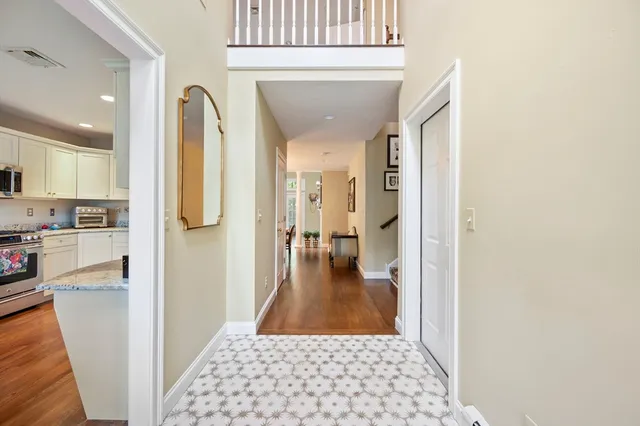 a view of a hallway with wooden floor and a living room