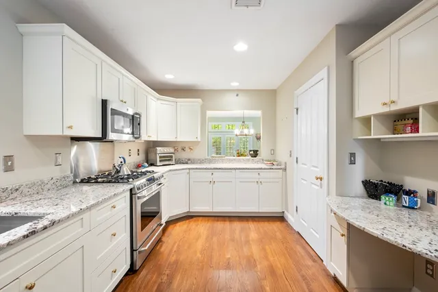 a kitchen with granite countertop white cabinets and white appliances