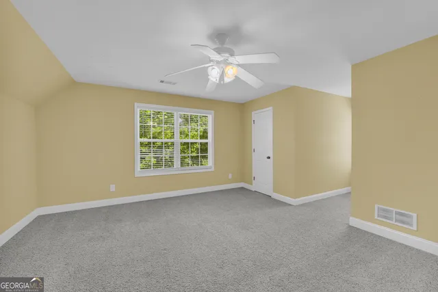 a view of empty room with ceiling fan