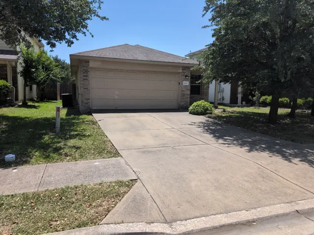 a front view of a house with a yard and a garage