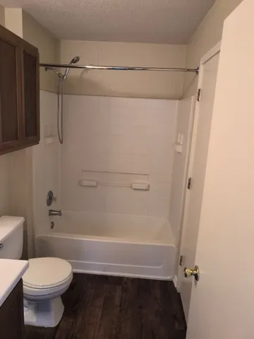 a bathroom with a shower a toilet and a sink