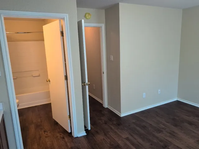 an empty room with wooden floor and a window