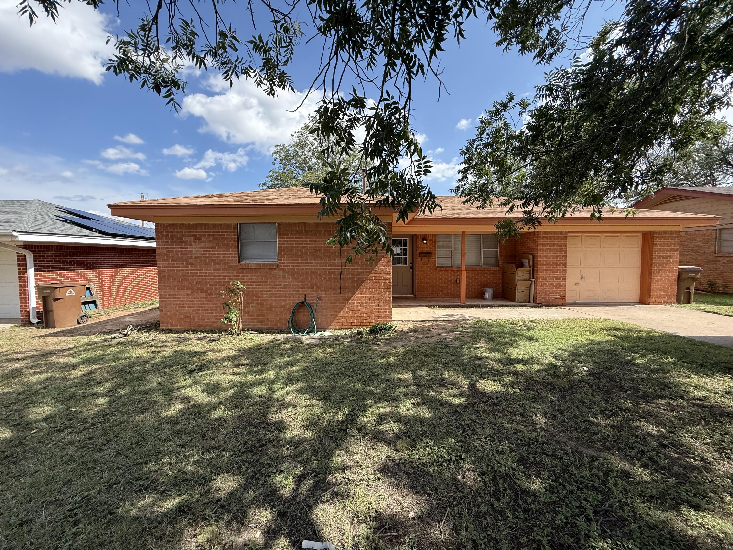 3232 Drexel Avenue Big Spring, TX 79720 - Photo 1 of 1 a front view of a house with a yard and garage