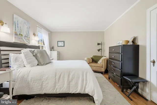 a bedroom with a bed and a flat tv screen on dresser