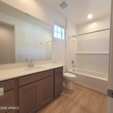 a bathroom with a double vanity sink toilet mirror and bathtub
