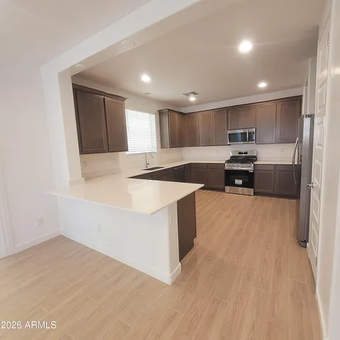 a kitchen with stainless steel appliances granite countertop a sink a stove a refrigerator and cabinets