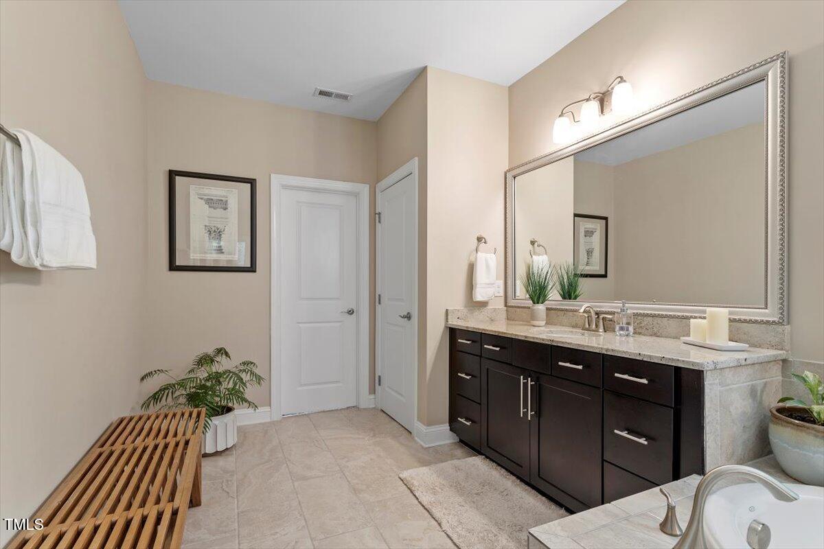 2421 Trenton Park Lane Raleigh, NC 27607 - Photo 39 of 66 a spacious bathroom with a granite countertop sink a toilet and a mirror